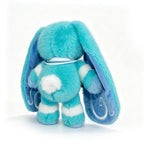 A fluffy blue Dysautonomia Rabbit with long ears, white spots, and a sailor collar, shown from the back.