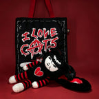 Autographed Emily the Strange and Plushie Dreadful Rabbit collaboration collector set with a black and red goth bunny plush toy, an I Love Cats canvas tote bag, ink pen, coin purse, and signed card by American McGee and Rob Reger.