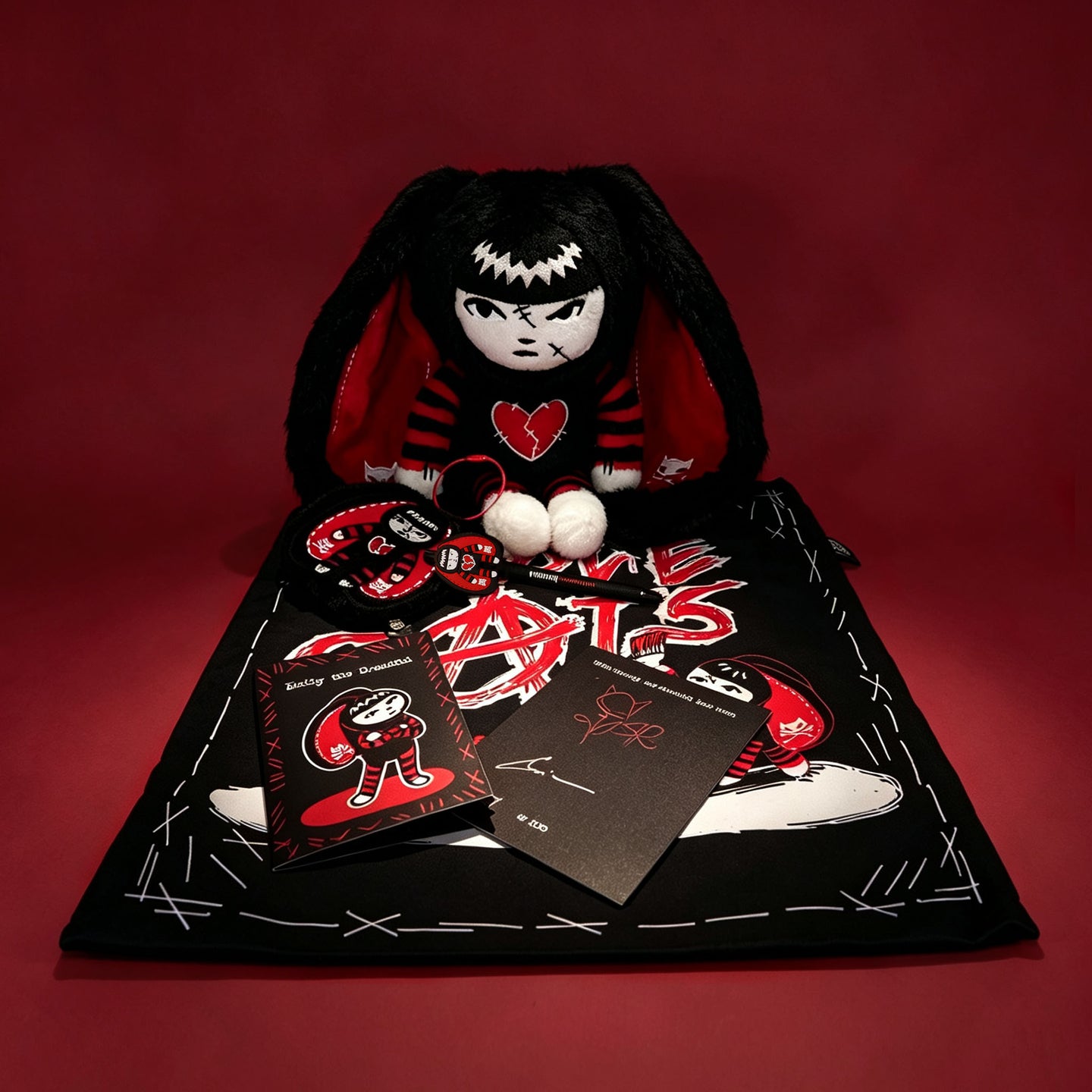 Autographed Emily the Strange and Plushie Dreadful Rabbit collaboration collector set with a black and red goth bunny plush toy, an I Love Cats canvas tote bag, ink pen, coin purse, and signed card by American McGee and Rob Reger.