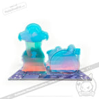 Colorful, translucent blue and pink modular acrylic pieces shaped like trees and a house on a patterned board.