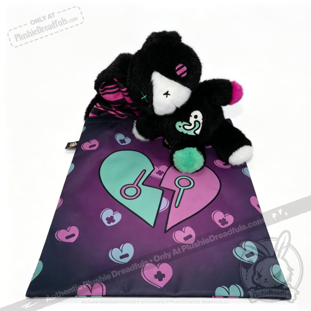 A black plush bear and small bear sit on a heart mat—an ideal mental health gift for comfort and support.