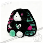 Plush black bunny with mismatched paws and striped ears—an emotional support bunny perfect as a mental health gift.