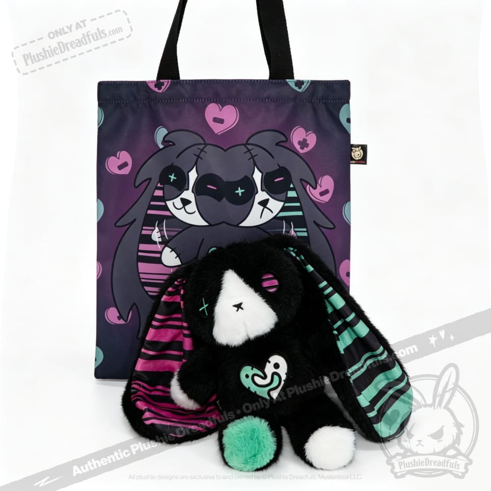 Plush black bunny, an emotional support bunny, sits before a tote bag adorned with hearts and matching art.