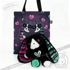Plush black bunny, an emotional support bunny, sits before a tote bag adorned with hearts and matching art.