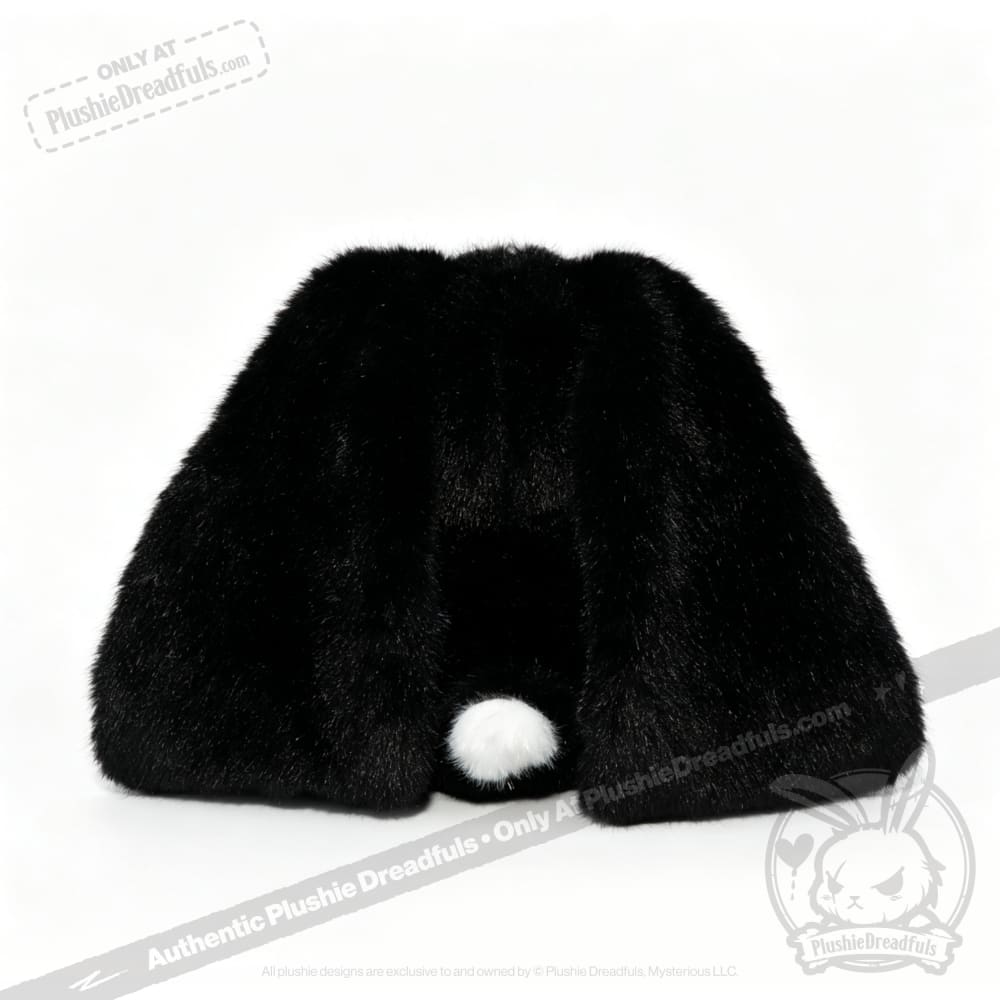 A black, furry object with long ear-like shapes and a small white ball—an ideal mental health gift resembling a bunny.