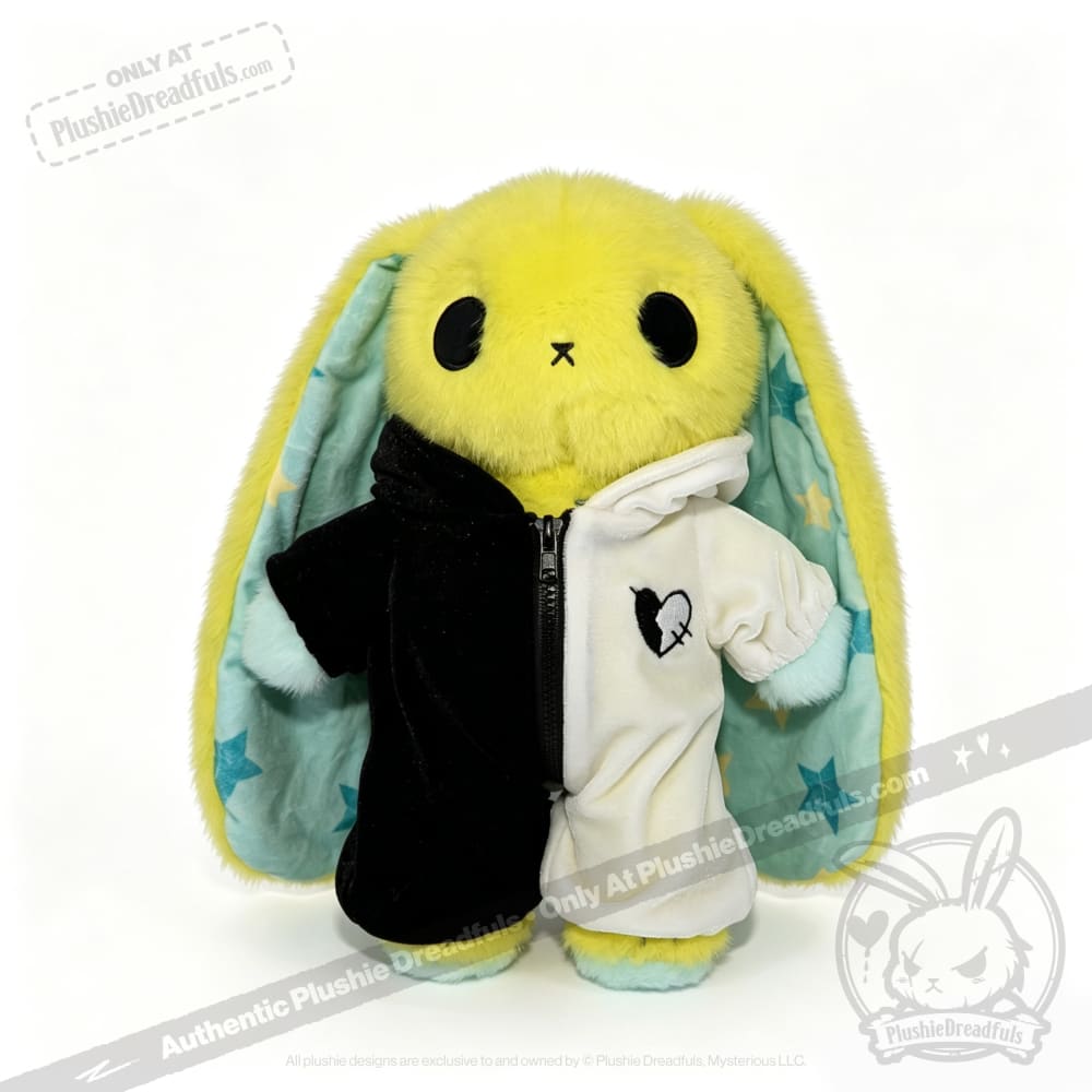 Plushie Dreadfuls yellow bunny in a black-and-white plushie jumpsuit, blue star ears, stands on a white background.