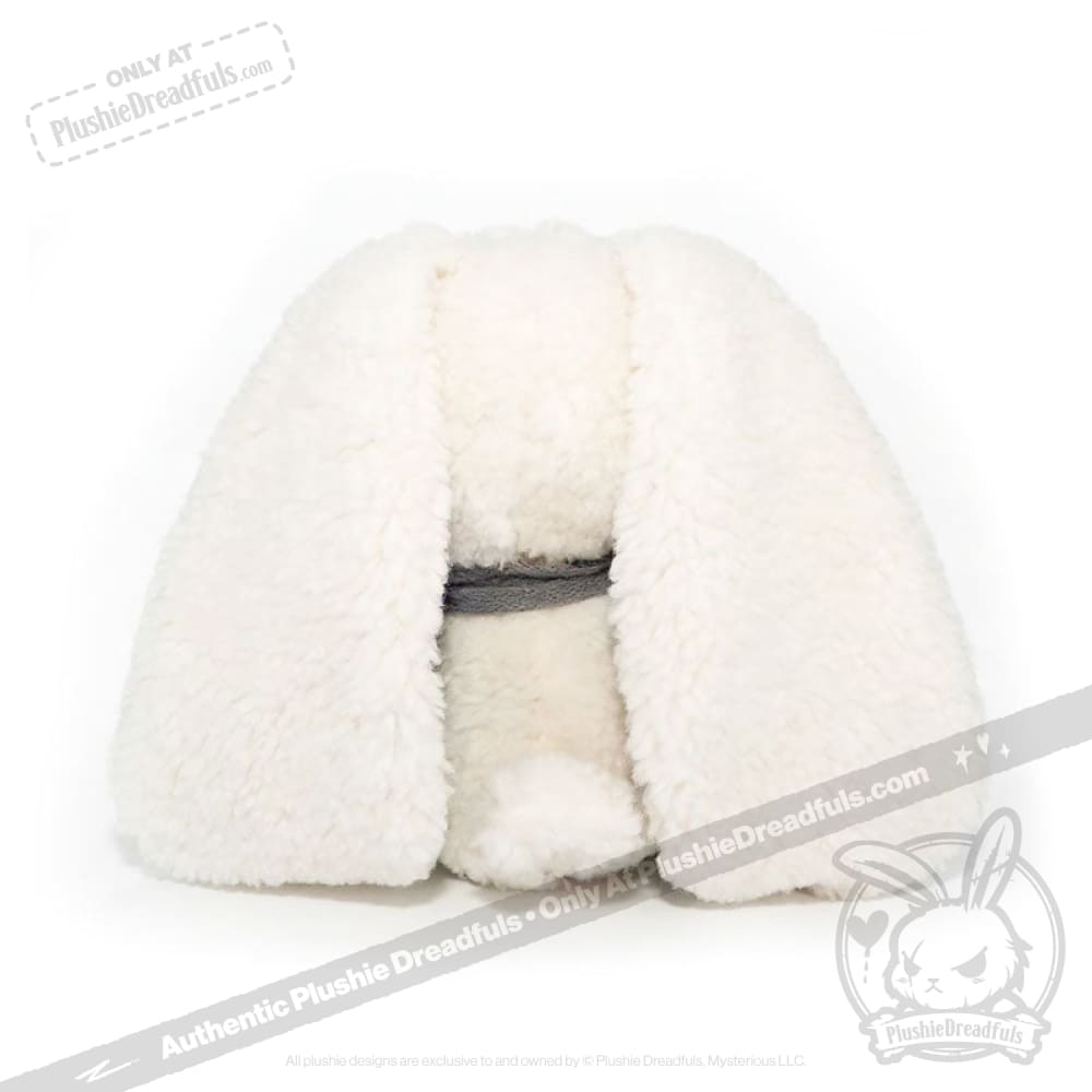 Plush white bunny toy faces backward, its floppy ears and round tail evoke seas of love on a crisp white background.