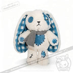 Blueplaid plush bunny with blue patches, button eyes, and a gray scarf—perfect for sharing seas of love.