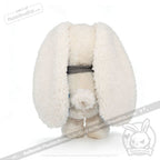 Fluffy white Blueplaid plush toy with long ears, facing backward, stands on a white background.
