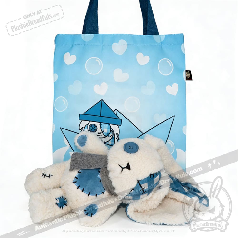A blueplaid plush bunny rests before a blue tote with hearts and a bunny graphic, evoking Seas of Love.