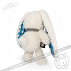 A fluffy white stuffed bunny with long ears lined in Blueplaid plush, facing away from the camera.