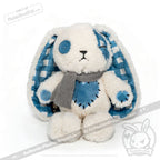 Plush white bunny with blueplaid ears, button eyes, blue patches, gray scarf—perfect for Seas of Love cuddles.