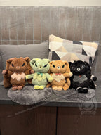 Four plush animal toys, including Latte Lapin plushies, sit side by side on gray mats with pillows behind them.