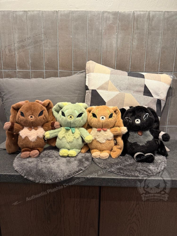 Four plush animal toys, including Latte Lapin plushies, sit side by side on gray mats with pillows behind them.
