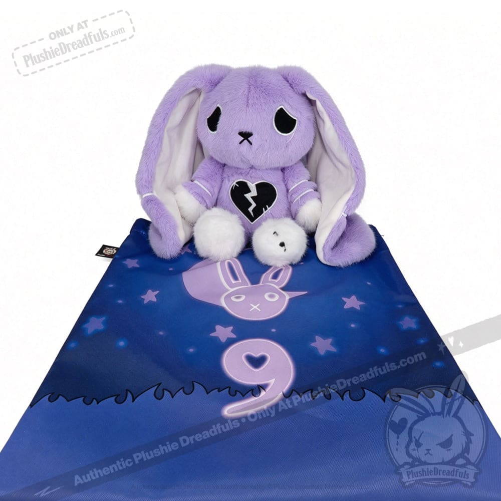 A purple plush bunny for depression awareness with a broken heart sits on a blue mat with stars and number 9.