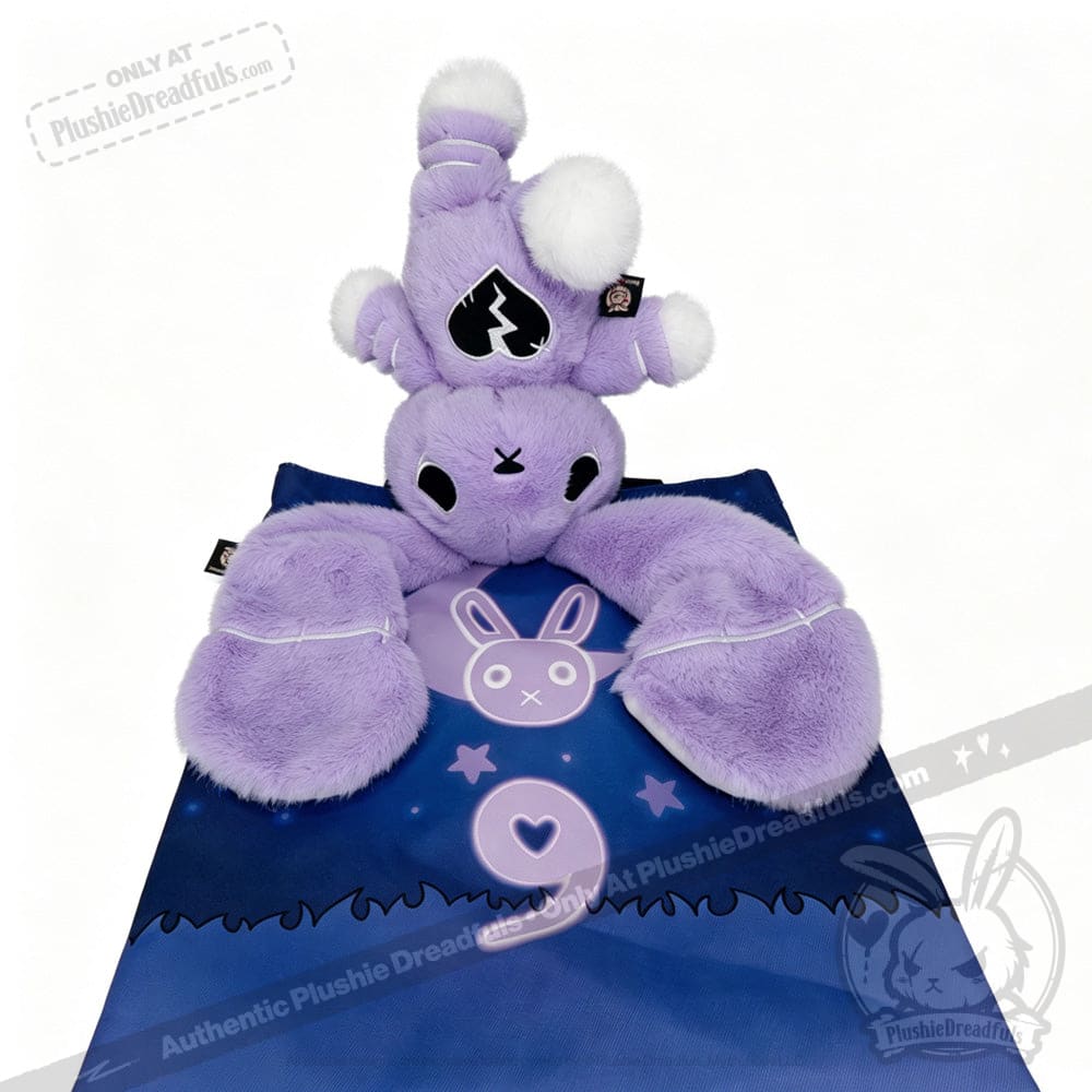 Plush purple bunny with a crown lies on a blue blanket featuring a semicolon symbol and heart for depression awareness.