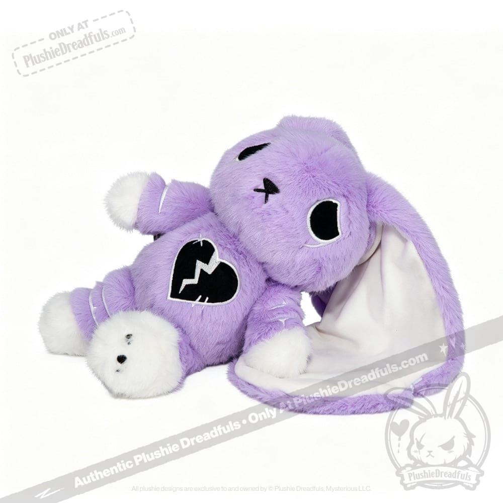 A LIMITED EDITION plush purple bunny with a broken heart emblem, white paws, and one floppy ear lined with white fabric.