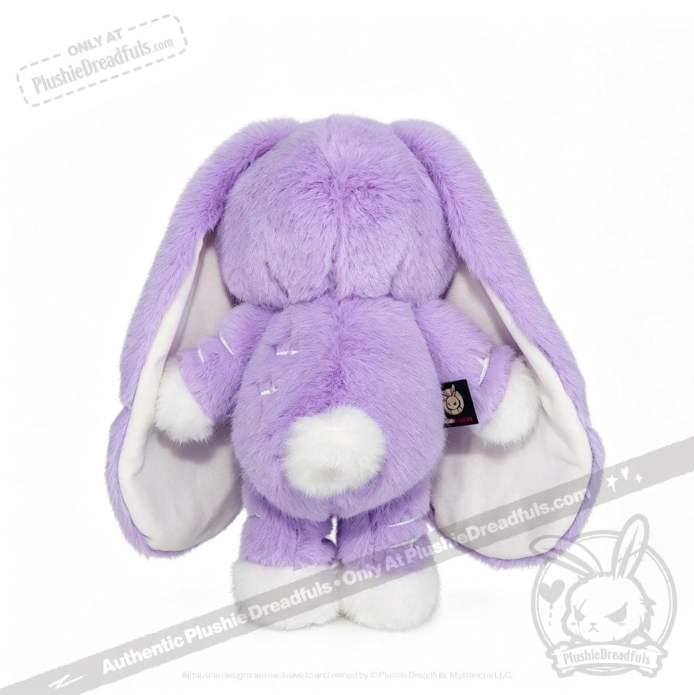 A plush purple bunny with long floppy ears, LIMITED EDITION, features a white fluffy tail and a subtle semicolon symbol.