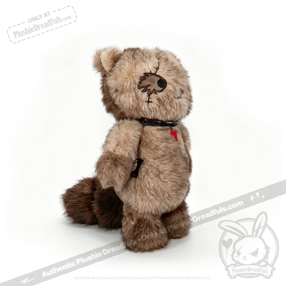 Plushie Dreadfuls raccoon with a red heart patch and black collar, from plushiedreadfuls.com, stands upright.