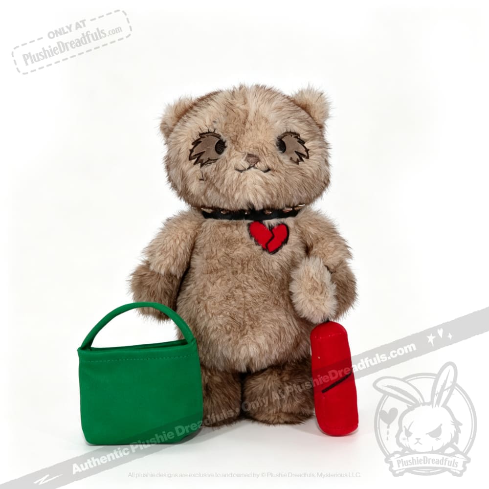 A Plushie Dreadfuls bear with a heart patch holds a green bag and red item, from plushiedreadfuls.com.