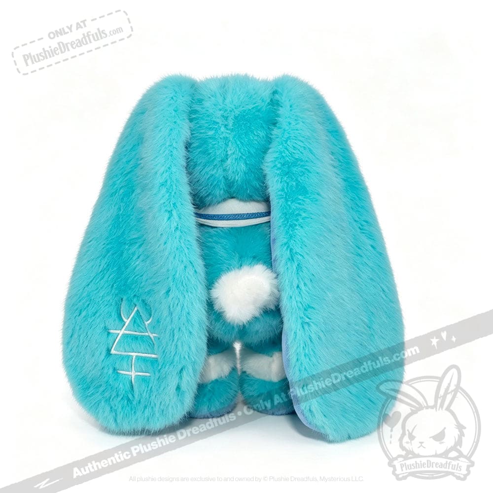 Plush blue Dysautonomia Rabbit toy with long droopy ears, white tail, and embroidered ear, facing away.
