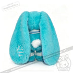 Plush blue Dysautonomia Rabbit toy with long droopy ears, white tail, and embroidered ear, facing away.