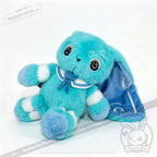 A turquoise Dysautonomia Rabbit with a blue bow and long floppy ears sits on a white background.