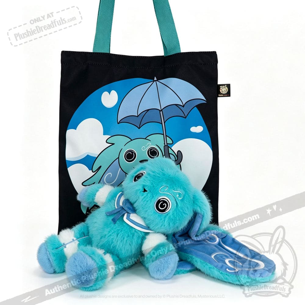 Plush blue Dysautonomia Rabbit toy with floppy ears lies in front of a black tote bag with an umbrella design.