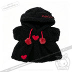 Small black Plushie Hoodie with red pom-pom strings and heart patches, designed for a child or a doll.