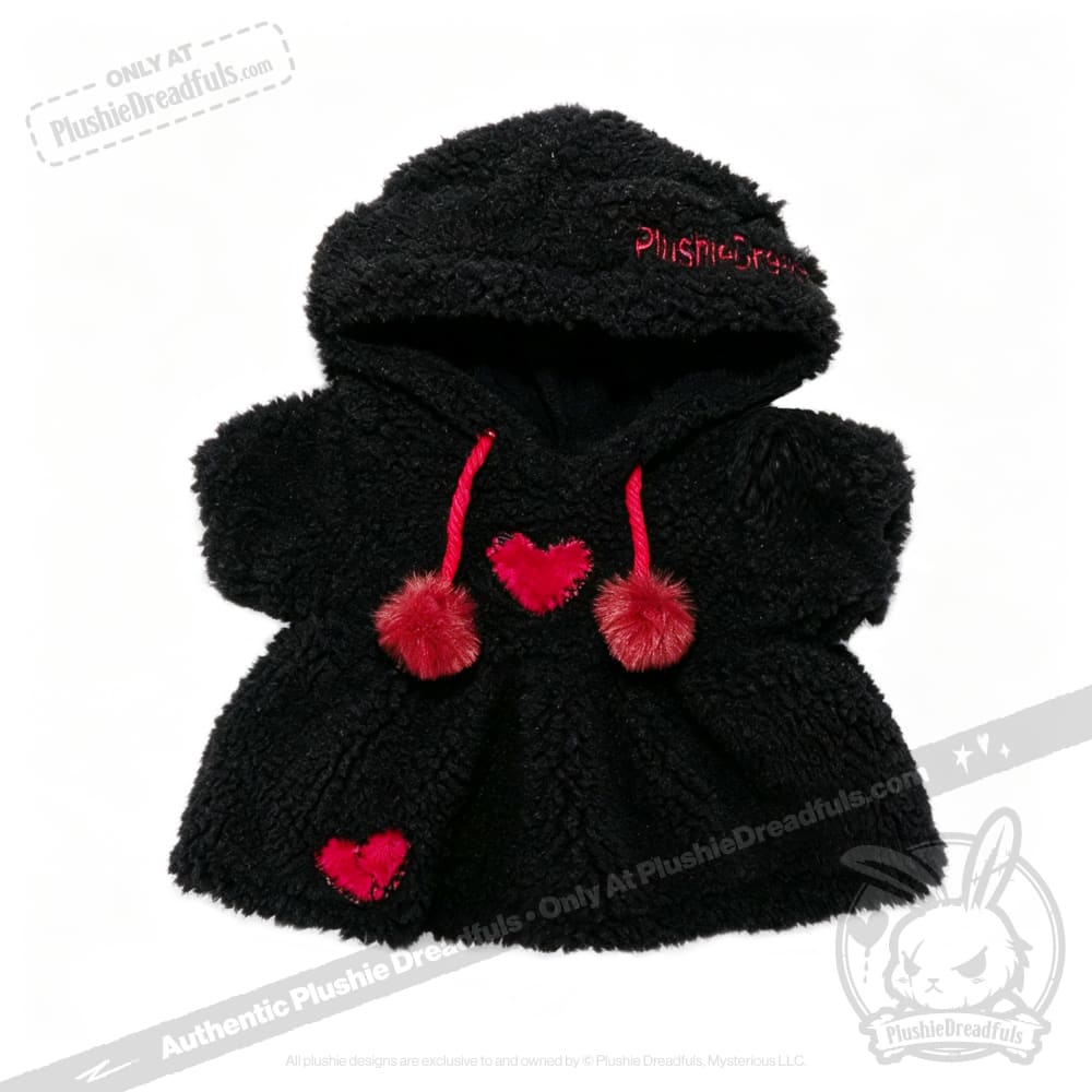 Small black Plushie Hoodie with red pom-pom strings and heart patches, designed for a child or a doll.