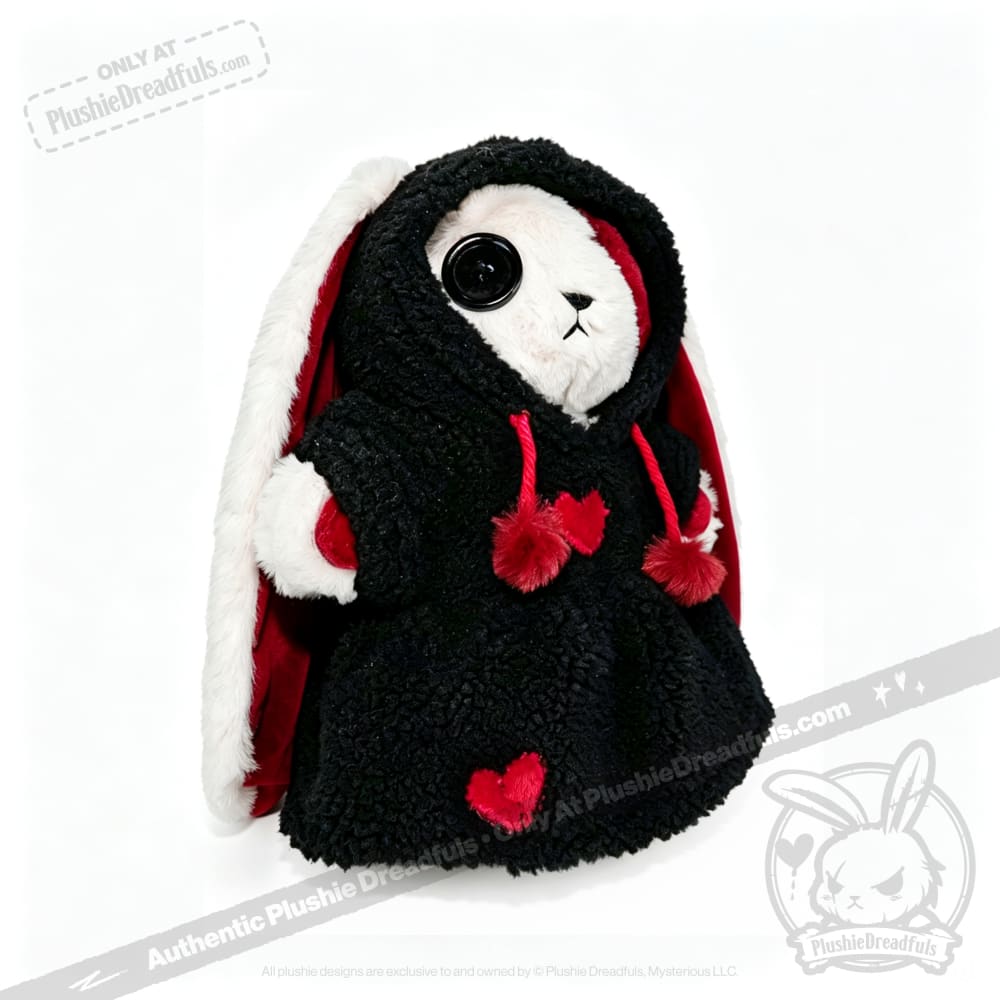Plushie Dreadfuls bunny in a black hooded coat with red hearts and a large black button eye.