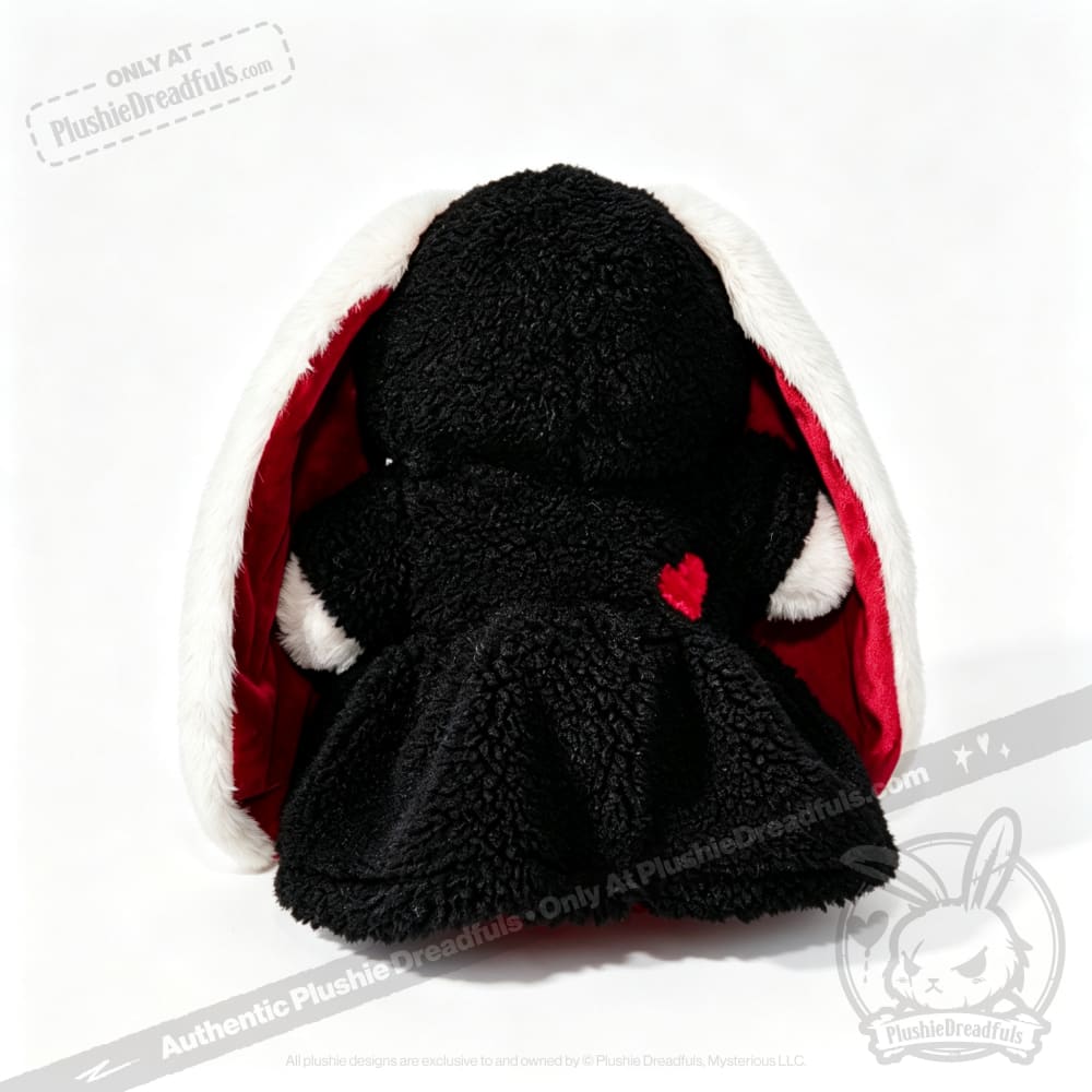 A Plushie Dreadfuls black bunny with long white ears, red heart, and cloak—perfect for plushie hoodie collectors.