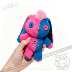 A hand holds a Gemini Rabbit plushie with button eyes, star chest, and cute Plushie Dreadfuls vibes.