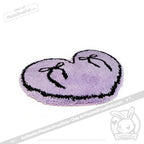 A purple goth floor rug, heart-shaped with a black outline and two black bows, perfect for unique decor.