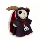 A Plushie Dreadfuls rabbit in a horned cloak holds a skull charm, exuding mysterious plushie magic.