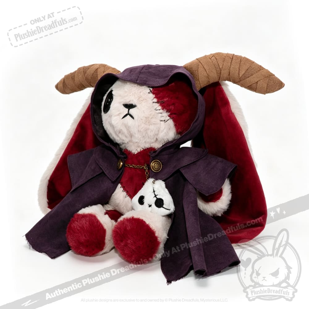 A Plushie Dreadfuls bear with ram horns, a red cape, and purple plushie cloak cuddles a matching mini plush in its lap.