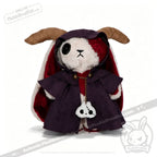 A Plushie Dreadfuls bunny with horns, a purple horned cloak, and a skull accessory on its chest.