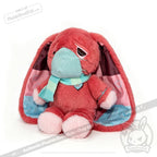 A pink awareness rabbit plushie with a teal mask and scarf sits on a white background, perfect as a chronic illness gift.