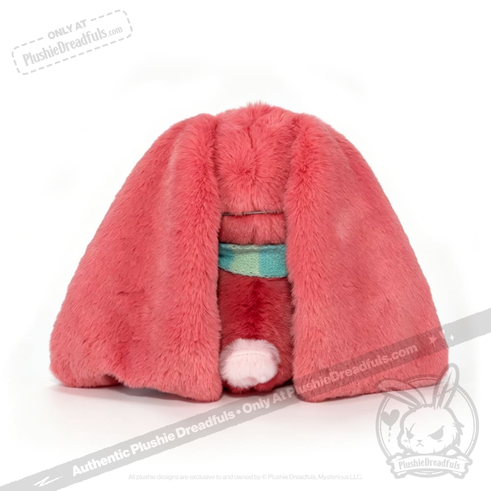 A plush toy with long pink fur, floppy ears, and a teal collar—an adorable Long COVID plushie on a white background.