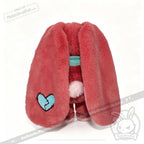 Plush pink bunny doll with long ears, blue heart patch—an adorable chronic illness gift or Long COVID plushie.
