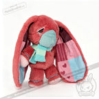 Plush pink awareness rabbit with patchwork ears, blue mask, and striped scarf—thoughtful chronic illness gift.
