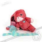 Pink plush bear with a heart patch, a symbolic chronic illness gift, sits by a blue and white knitted scarf and yarn.