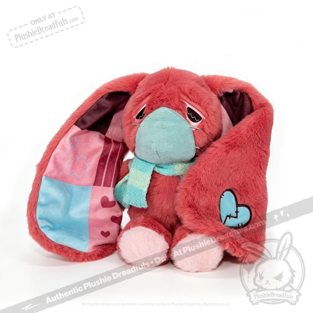 Sad pink awareness rabbit with long ears, blue scarf, and broken heart patch—a tender chronic illness gift.