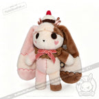 Neapolitan Bunny: Super soft rabbit plushie with pink, brown fur, cupcake hat, bow, and heart detail on its cheek.