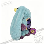 A blue Pisces Rabbit plush zodiac stuffed animal sits beside a purple and yellow die on a white background.