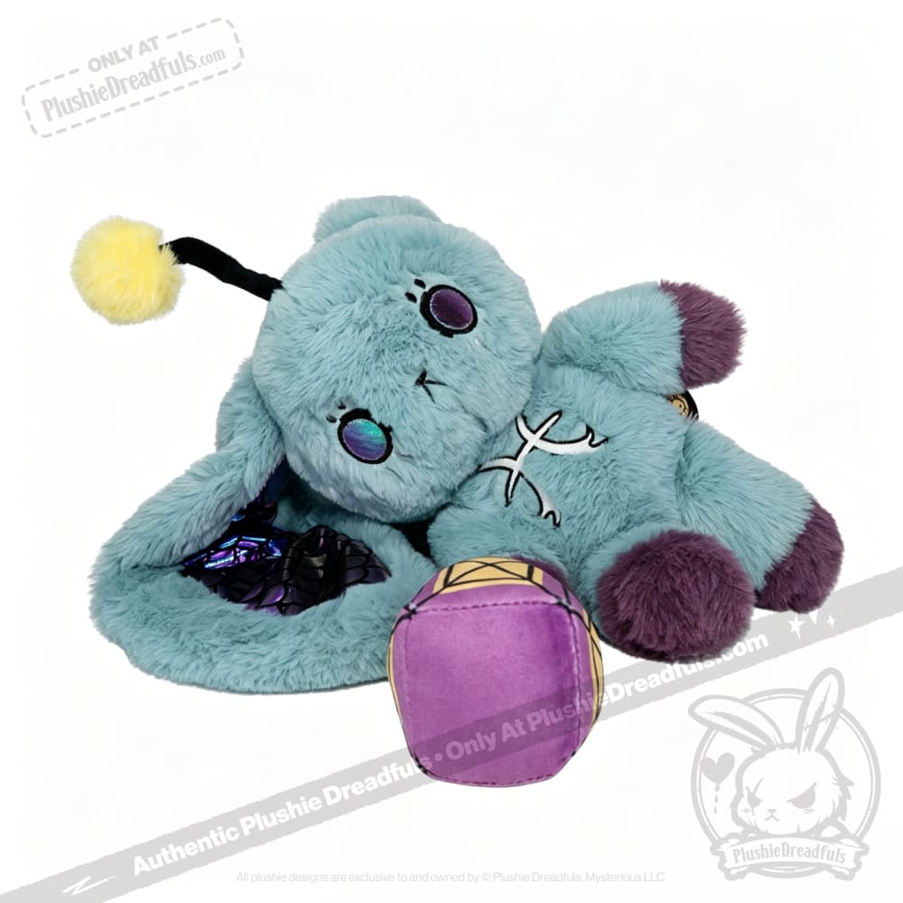 Blue Pisces Rabbit plushie with purple feet, butterfly wings, and a Plushie Dreadfuls zodiac stuffed animal cube nearby.