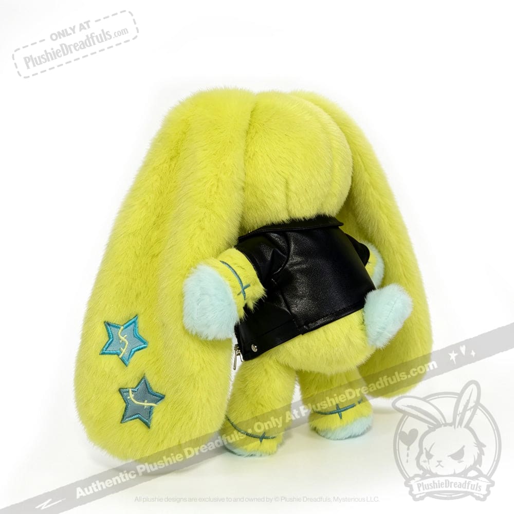 A plush yellow bunny with long ears, blue stars, and a faux leather jacket, facing away from the camera.