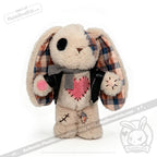 Plush bunny plushie jacket with button eye, plaid ears, scarf, and stitched pink heart patch on its chest.