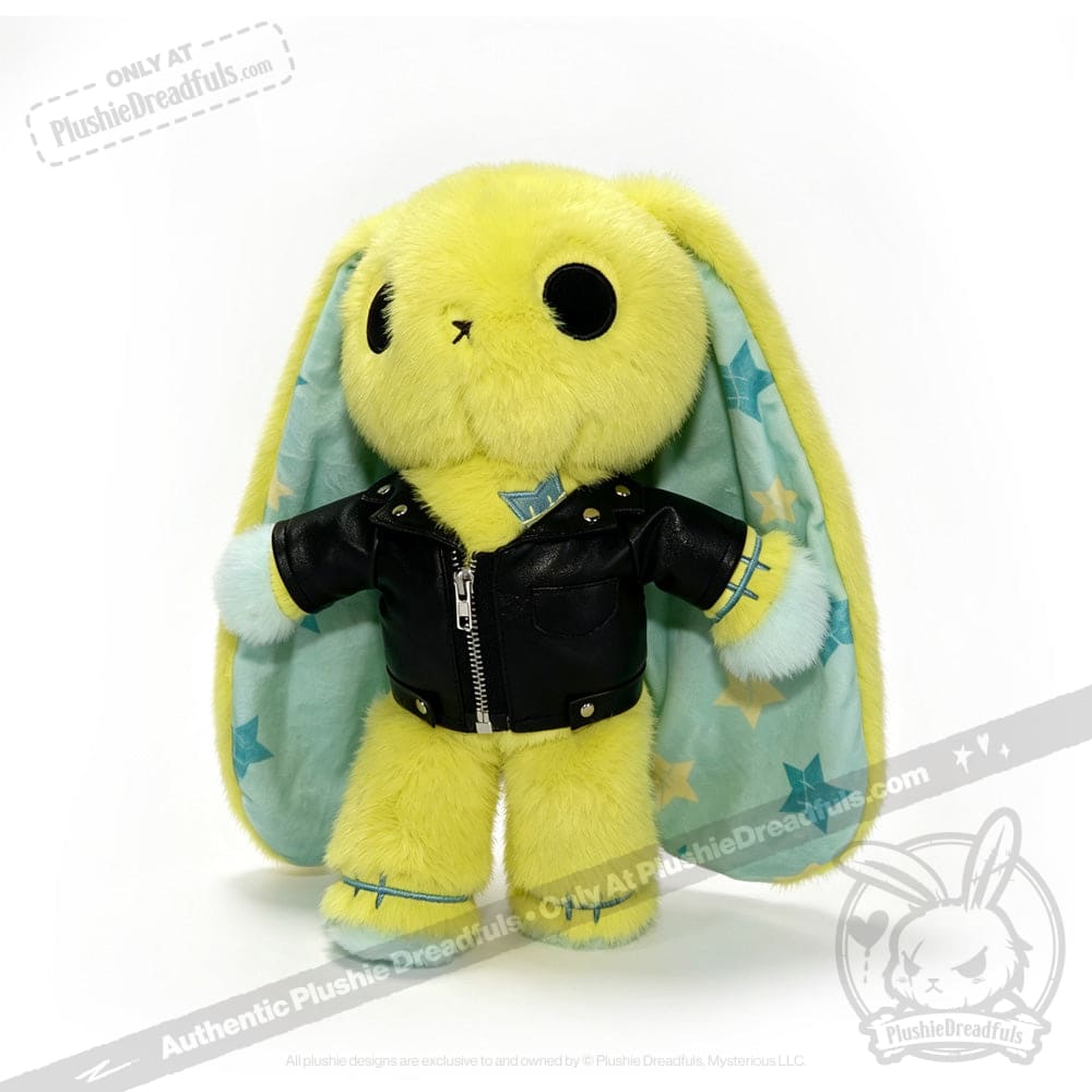 Yellow plush bunny in a faux leather jacket, with long blue star-patterned ears, stands upright on white background.