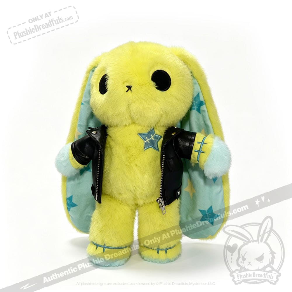 Plush yellow bunny with large black eyes, blue stars, and a faux leather jacket against a white backdrop.